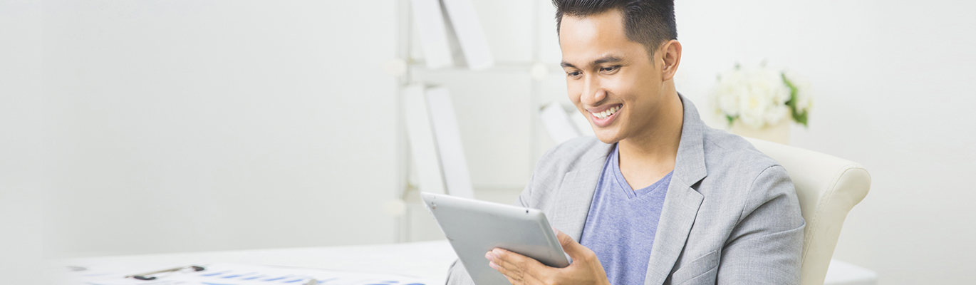 A person is looking at a tablet screen and smiling