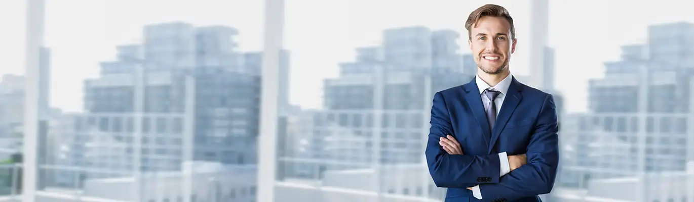 A Threat Intelligence Analyst standing with folded hands in an office space background