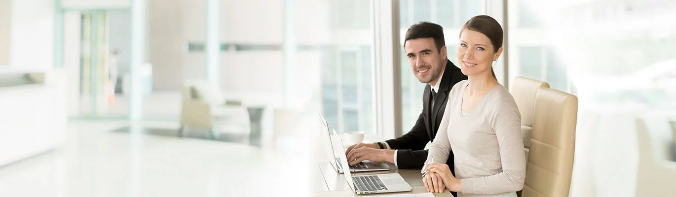 Two professionals sitting infront of a two laptops and learning FTTx Network Training