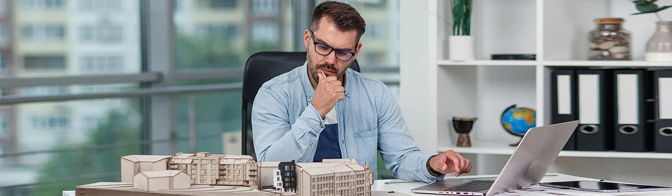 AutoCAD 3D professional sitting infront of a laptop and monitoring 3d property