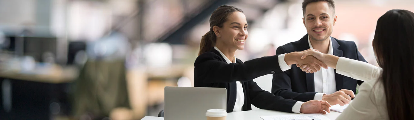 Two professionals sitting with a laptop welcoming a new trainer for SAP S/4HANA HCM Course 