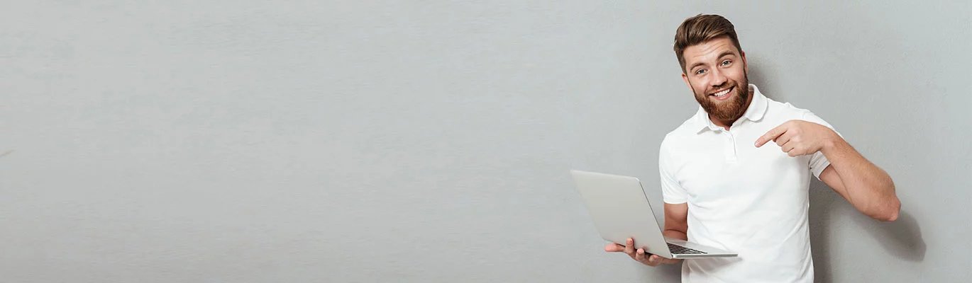 An Elasticsearch course trainer standing with a laptop in hand, pointing his finger to the laptop screen