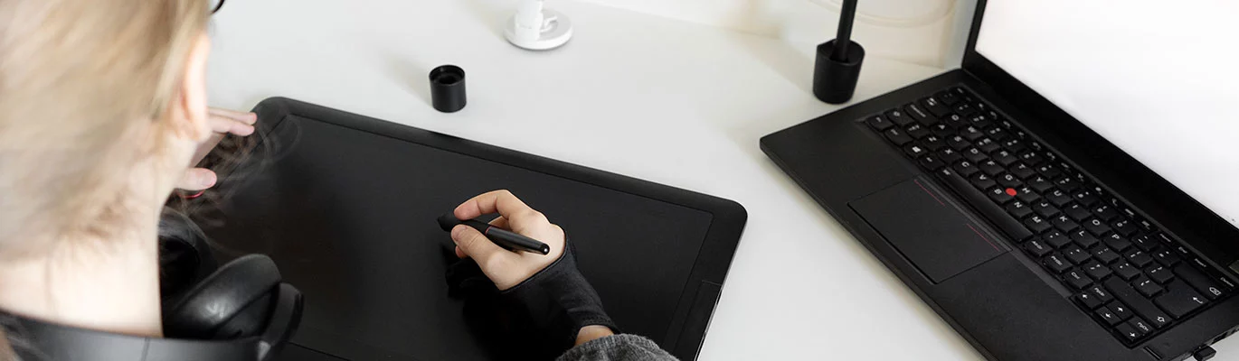 A student sitting infront of a laptop and learining Digital Painting Course with tablet