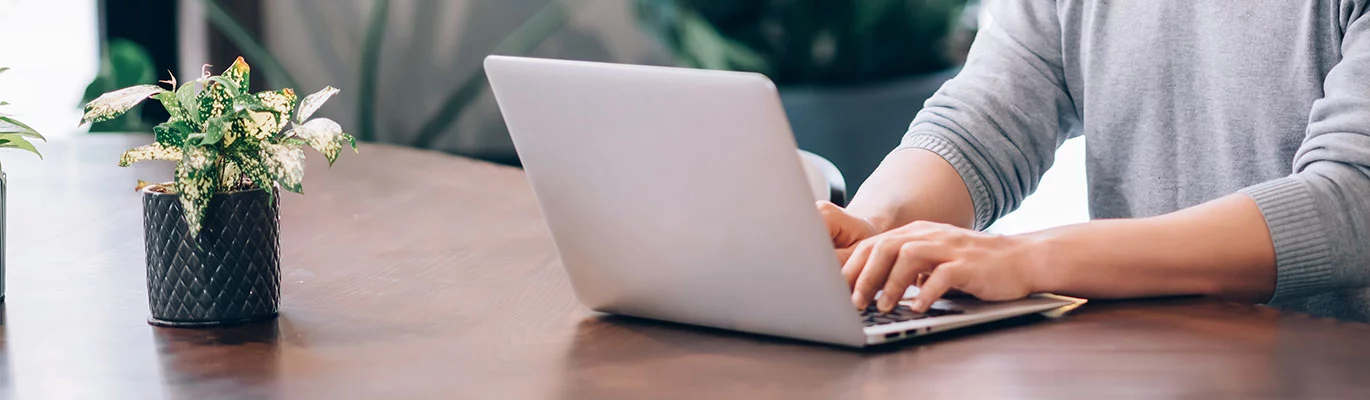 Hands of a Student on a laptop sitting at his space and attending MongoDB Course 