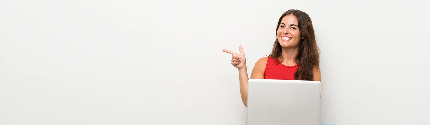 A Student attending SAP Netweaver Course with a laptop in left hand and pointing her finger to the right