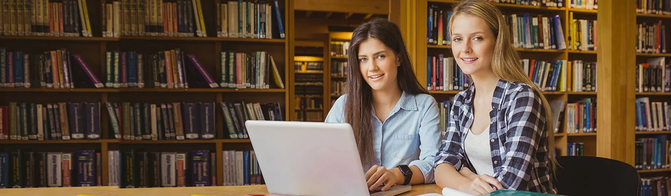 Two college students in library, sitting infront a laptop and learning Advanced English Course