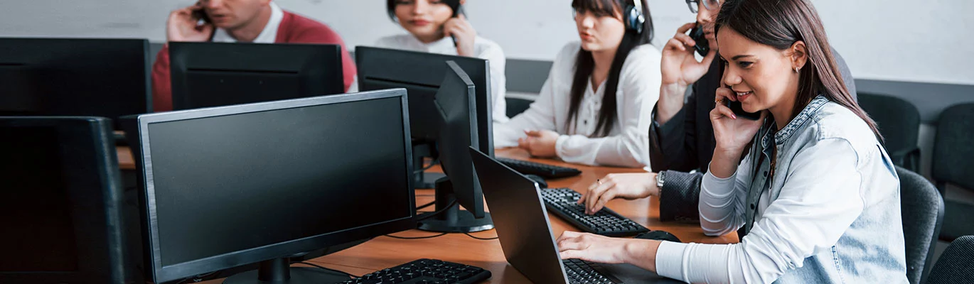 Professionals sitting infront of a laptops and learning Deep Learning Training with calling phones