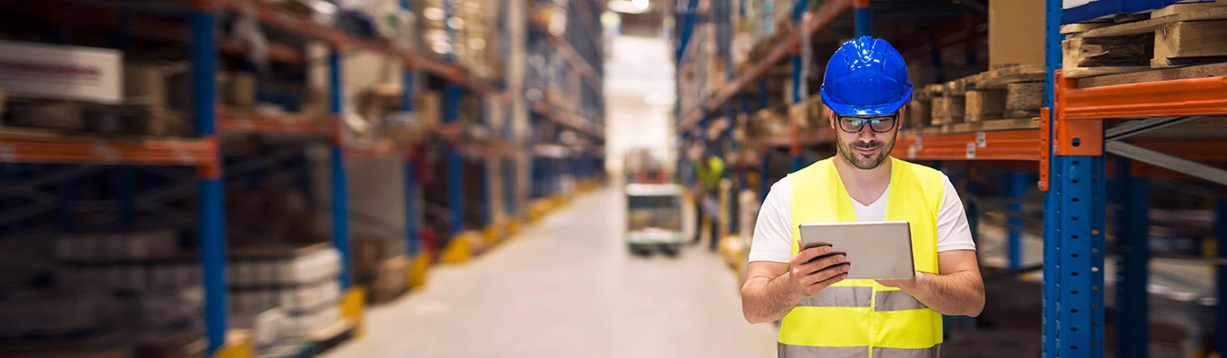 A Warehouse worker at work site checking the list of dispatched warehouse goods