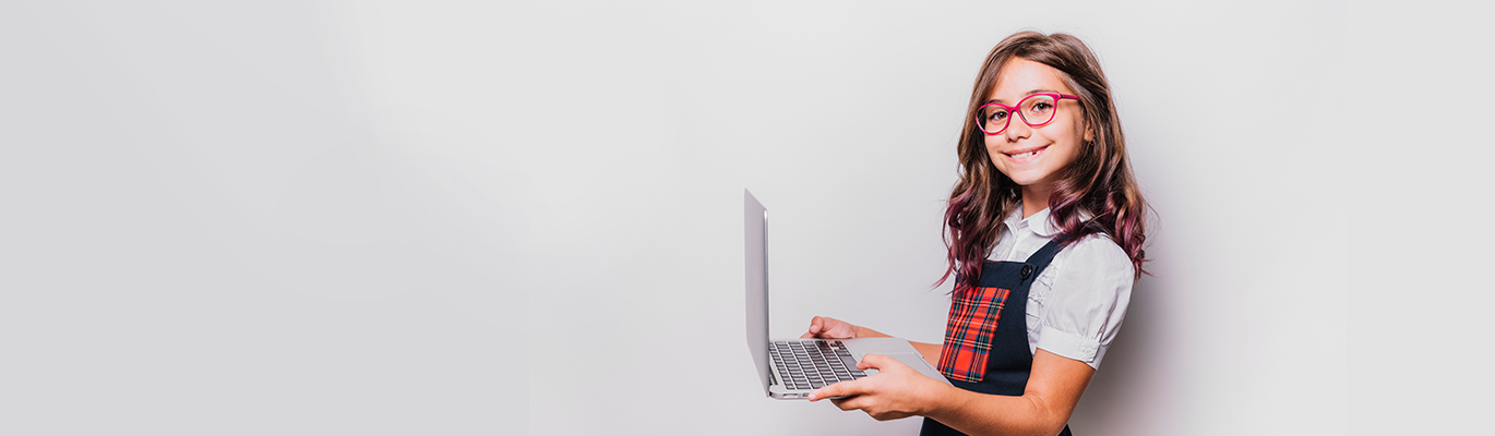 A kid holding the laptop and learning about Coding For Kids