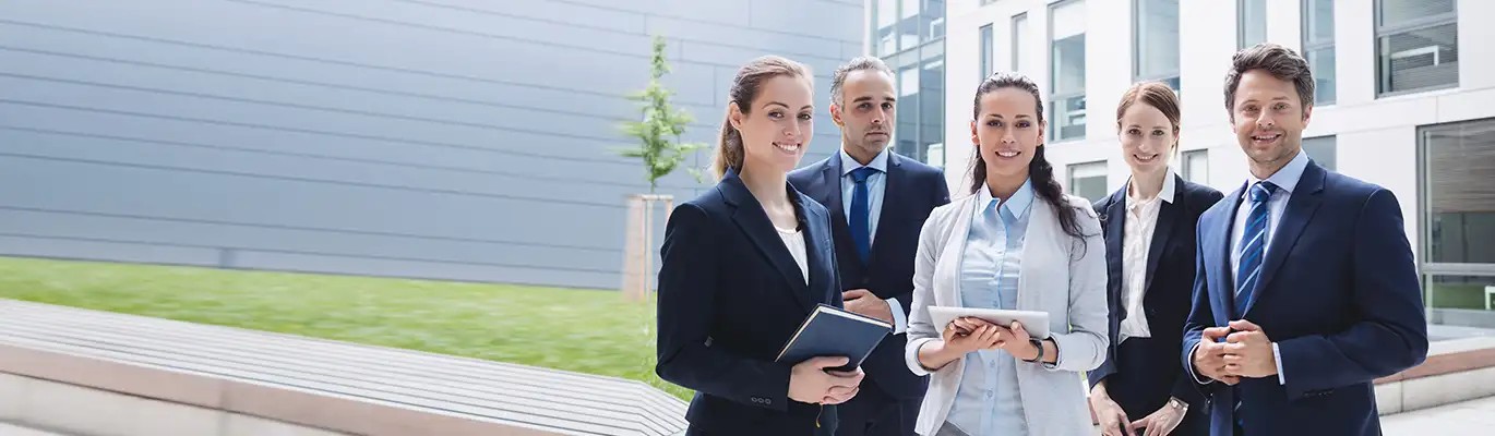 Team leader and members standing together holding books