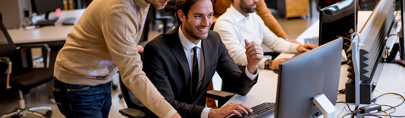 IT professionals discussing sitting infront of a computer