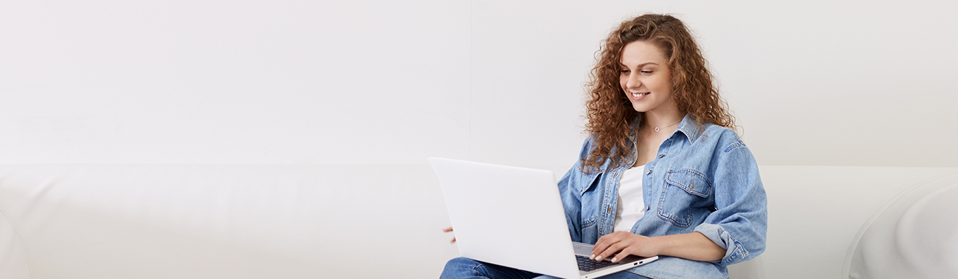 MCSE student sitting infront of a laptop ad smiling