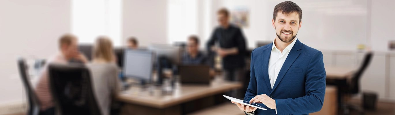 An HR professional holding a tablet smiling at the camera