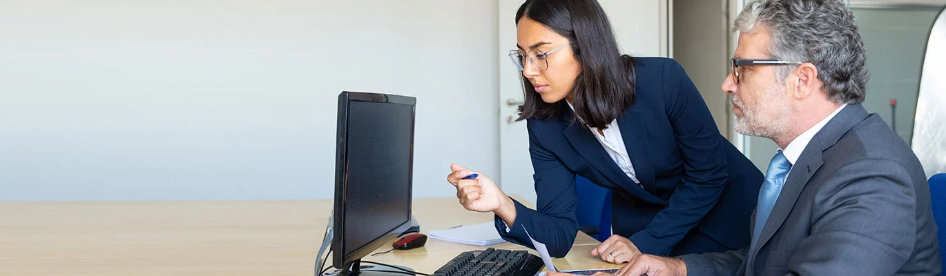 Two students using a computer to learn about business management 