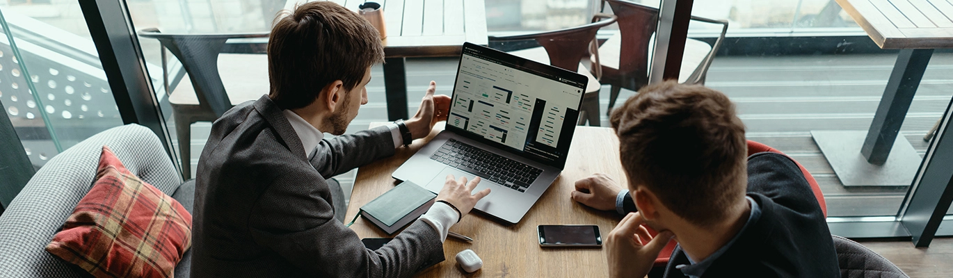 Business Operations professionals sitting together infront of a laptop and discussing